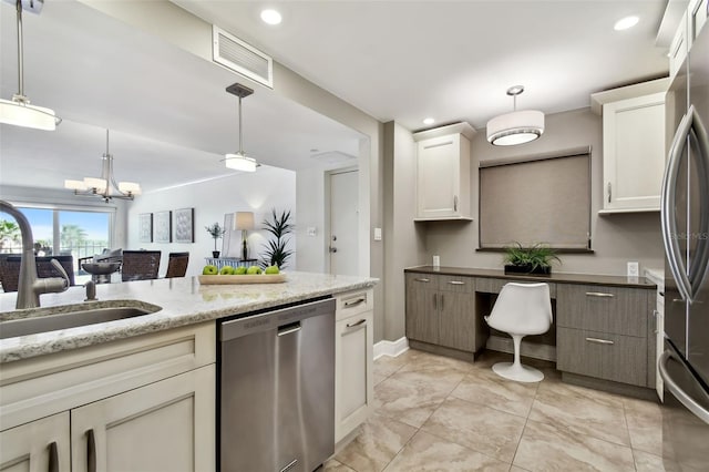 kitchen with stainless steel appliances, sink, pendant lighting, and a notable chandelier