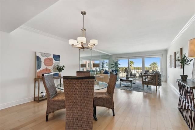 dining room featuring light hardwood / wood-style floors, ornamental molding, and a chandelier