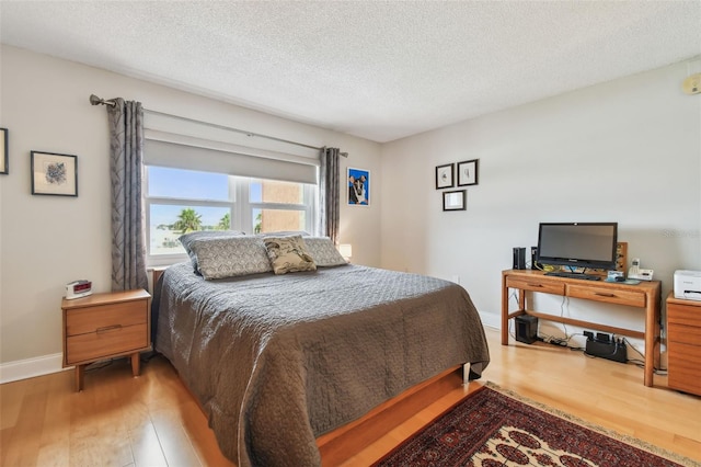 bedroom with a textured ceiling and hardwood / wood-style floors