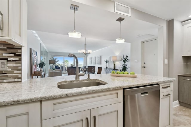 kitchen featuring light stone countertops, stainless steel dishwasher, hanging light fixtures, decorative backsplash, and sink