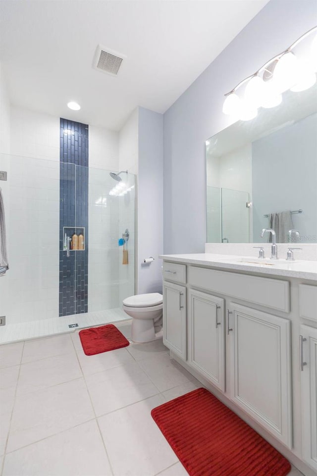 bathroom with toilet, a shower with door, vanity, and tile patterned floors