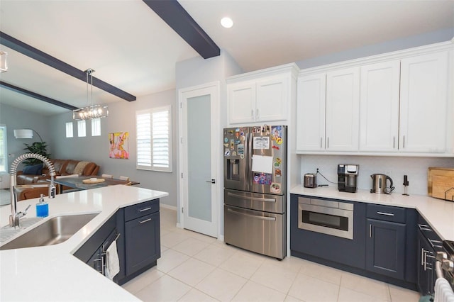 kitchen featuring sink, white cabinetry, an inviting chandelier, pendant lighting, and appliances with stainless steel finishes