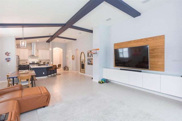 tiled living room featuring vaulted ceiling with beams