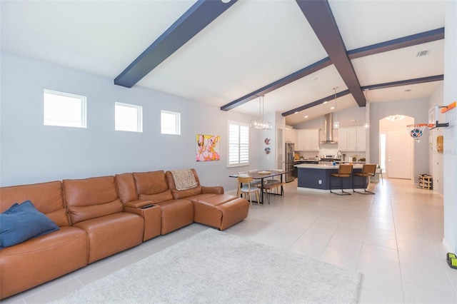 living room with light tile patterned floors and vaulted ceiling with beams