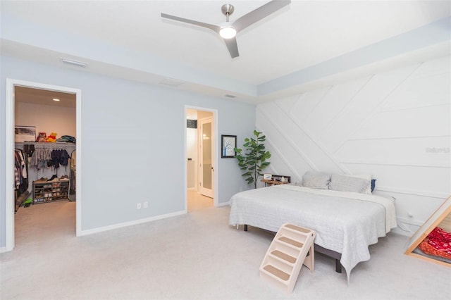 bedroom with a closet, light carpet, ceiling fan, and a spacious closet