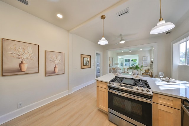 kitchen with stainless steel range with gas stovetop, a wealth of natural light, and pendant lighting