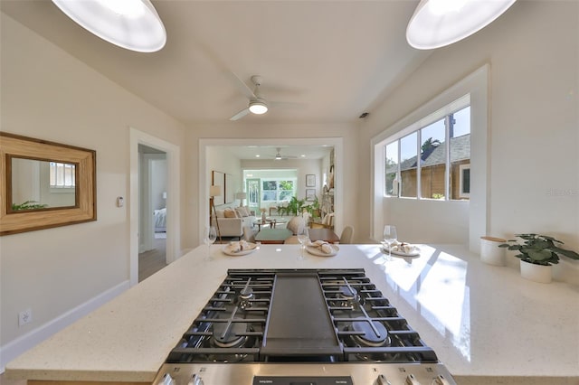 kitchen featuring ceiling fan, a wealth of natural light, and stainless steel gas stovetop