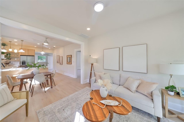 living room featuring light hardwood / wood-style floors and ceiling fan