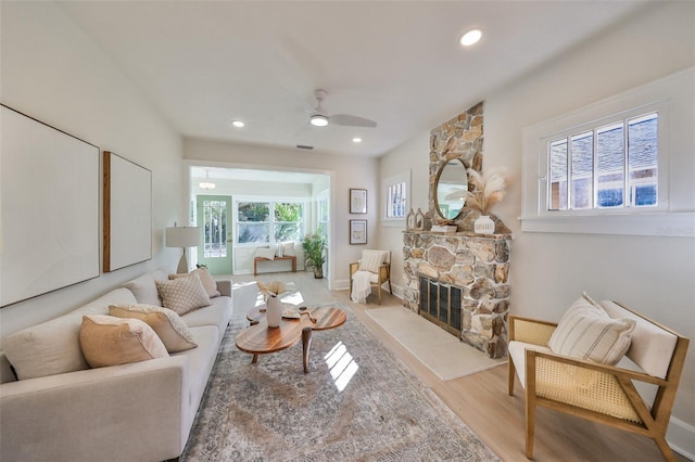 living room with ceiling fan, wood-type flooring, a fireplace, and a wealth of natural light