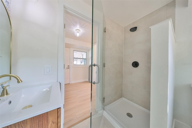 bathroom with vanity, a shower with shower door, and wood-type flooring