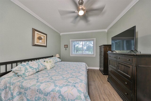 bedroom with crown molding, light hardwood / wood-style floors, and ceiling fan