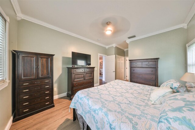 bedroom featuring light wood-type flooring, crown molding, and ceiling fan