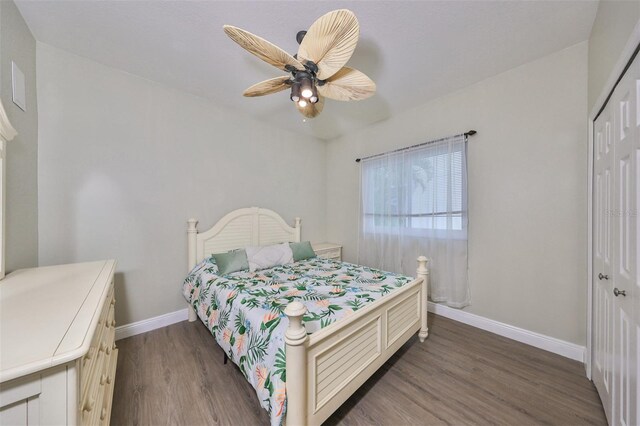 bedroom with ceiling fan, a closet, and dark wood-type flooring