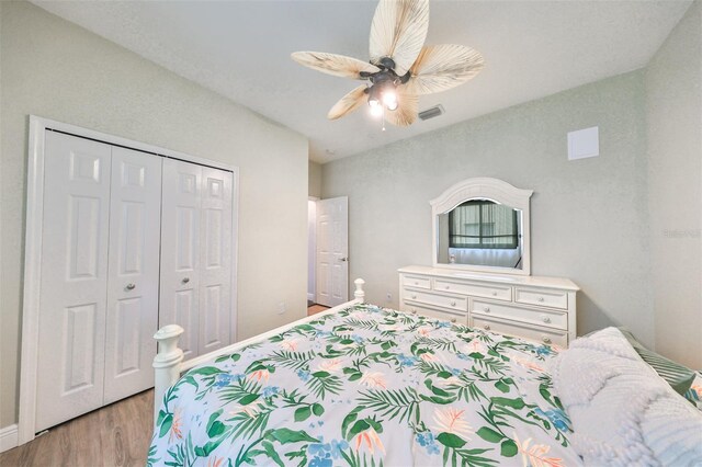 bedroom featuring light hardwood / wood-style flooring, ceiling fan, and a closet