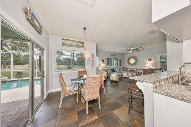 dining area with a wealth of natural light, ceiling fan, and sink