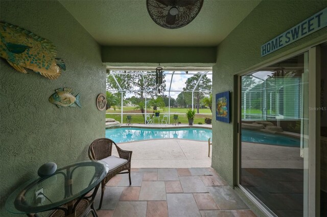 view of pool featuring a lanai, a patio, and ceiling fan