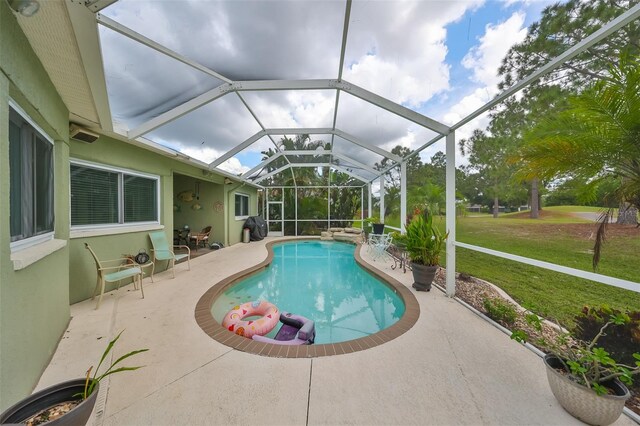 view of pool with a lawn, a patio, a lanai, and grilling area