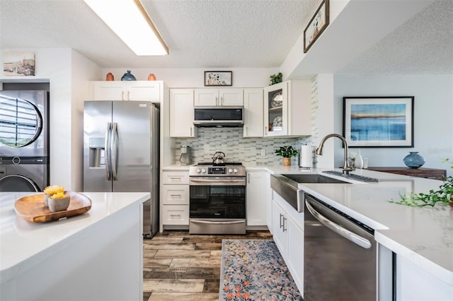 kitchen with white cabinets, sink, appliances with stainless steel finishes, and dark hardwood / wood-style flooring