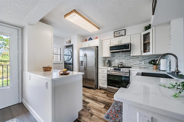 kitchen with dark hardwood / wood-style flooring, stainless steel appliances, white cabinets, and sink