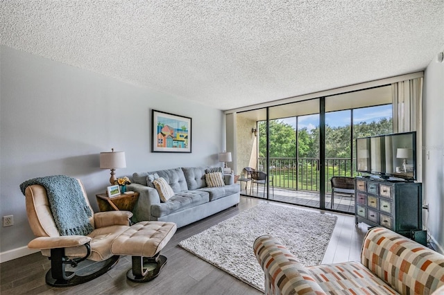 living room featuring hardwood / wood-style flooring, floor to ceiling windows, and a textured ceiling