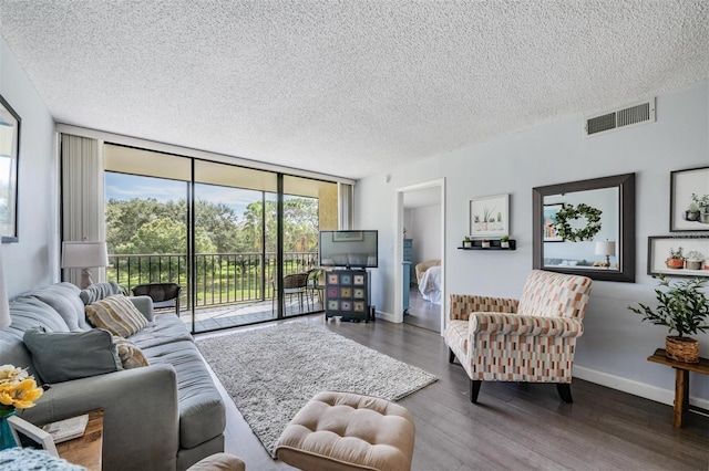 living room featuring a textured ceiling, a wall of windows, and dark hardwood / wood-style flooring