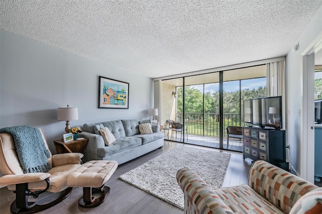 living room featuring a textured ceiling, hardwood / wood-style floors, and expansive windows