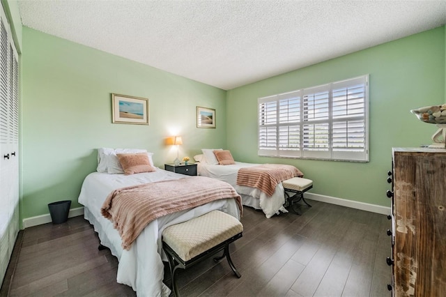 bedroom featuring a textured ceiling, dark hardwood / wood-style flooring, and a closet