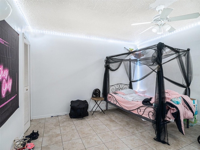 bedroom with light tile patterned floors, a textured ceiling, and ceiling fan