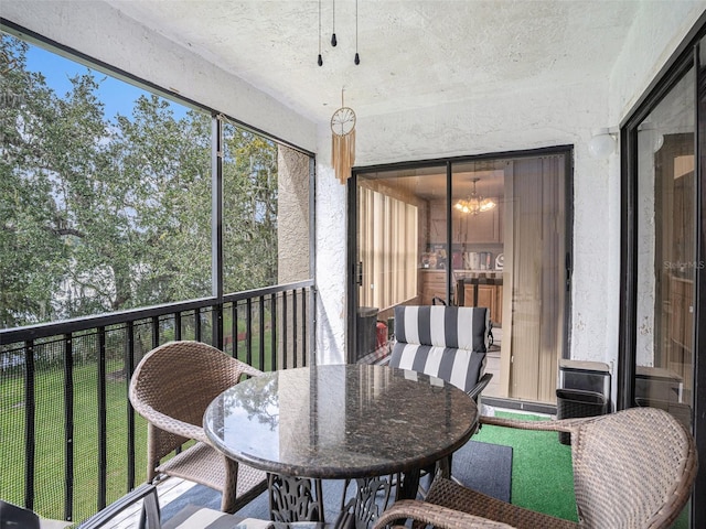 sunroom / solarium featuring a notable chandelier