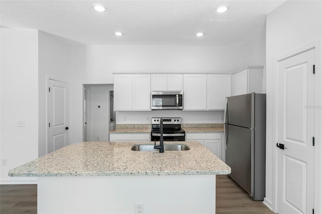 kitchen featuring white cabinets, an island with sink, appliances with stainless steel finishes, and light stone countertops