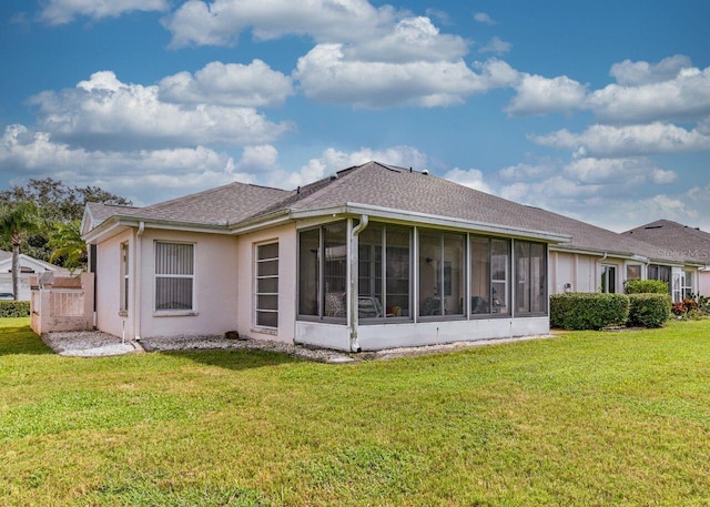 back of house with a sunroom and a yard