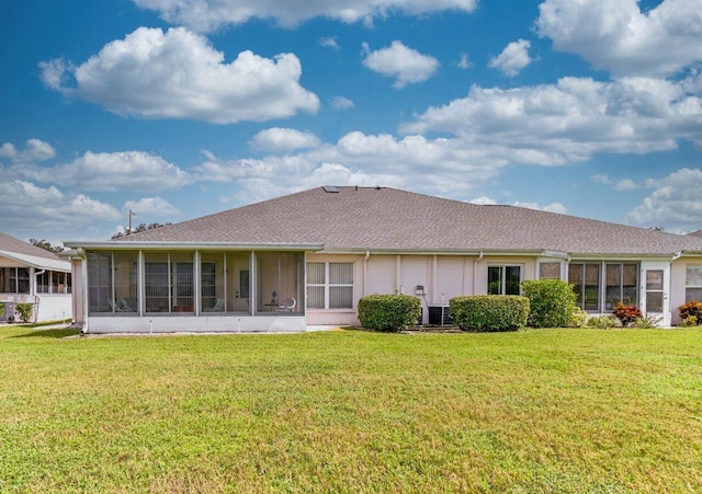 rear view of house with a sunroom and a yard