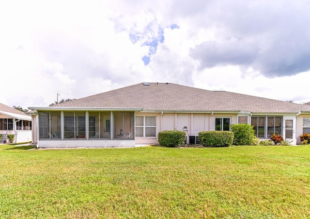 rear view of property with a lawn and a sunroom