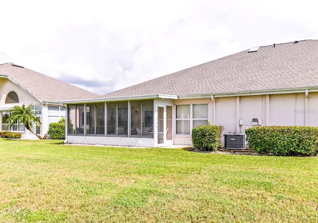 rear view of house featuring a sunroom, a yard, and cooling unit