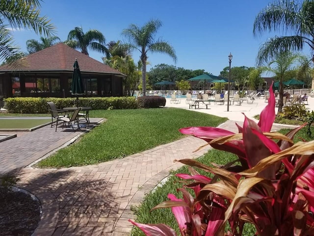 view of community with a pool and a yard