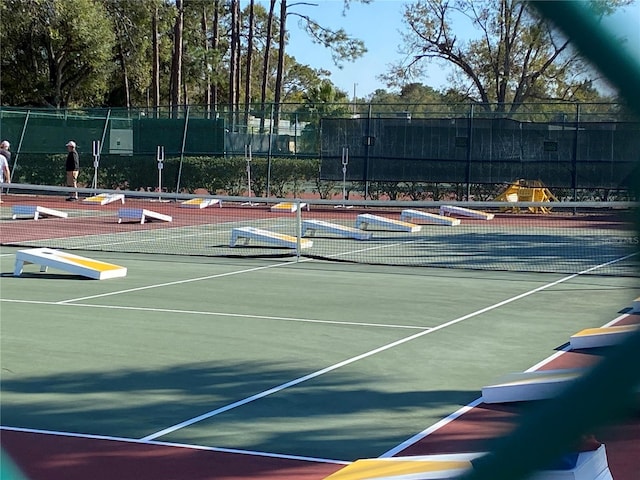 view of tennis court with basketball hoop