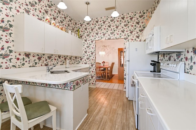 kitchen with white cabinetry, sink, light hardwood / wood-style flooring, white appliances, and decorative light fixtures