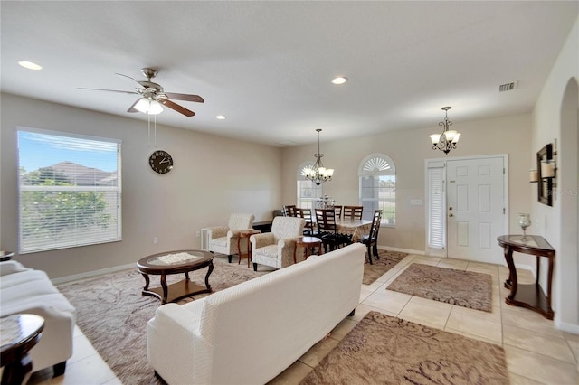 living room featuring ceiling fan with notable chandelier and light tile patterned floors