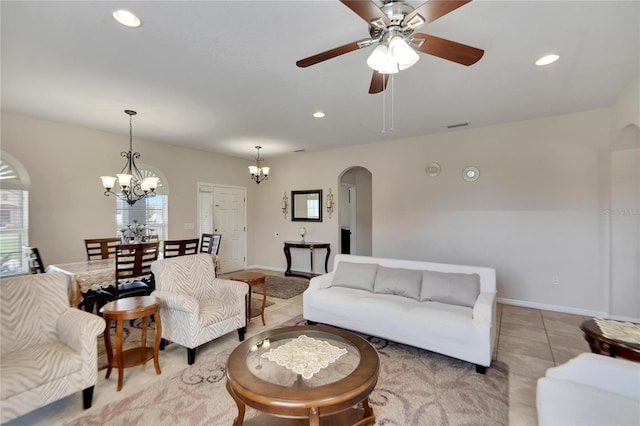 tiled living room featuring ceiling fan with notable chandelier