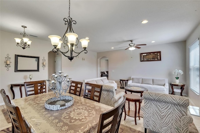 dining room with ceiling fan with notable chandelier and light tile patterned flooring