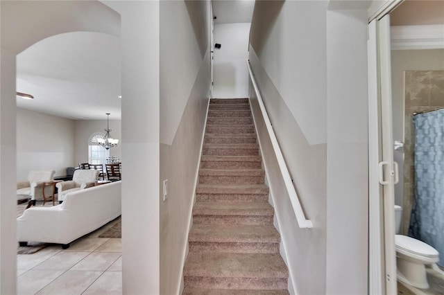 stairway with tile patterned flooring and a chandelier