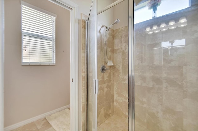 bathroom with a shower with door, tile patterned floors, and plenty of natural light