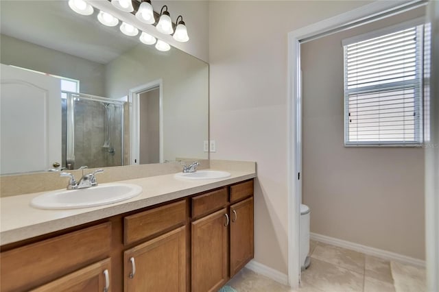 bathroom with a shower with door, toilet, vanity, and tile patterned floors