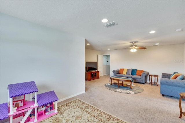 carpeted living room with ceiling fan