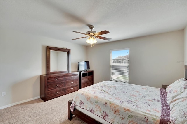 carpeted bedroom featuring ceiling fan and a textured ceiling