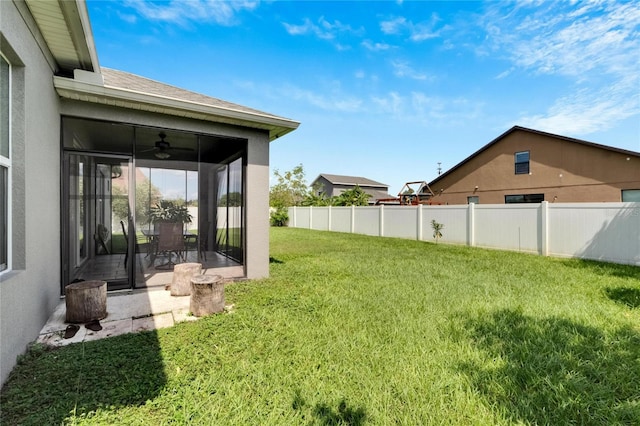 view of yard featuring a sunroom, ceiling fan, and a patio area