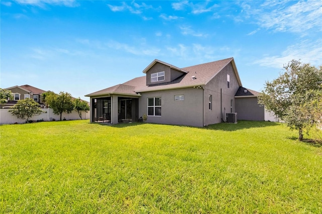 rear view of property featuring a sunroom, a lawn, and central AC