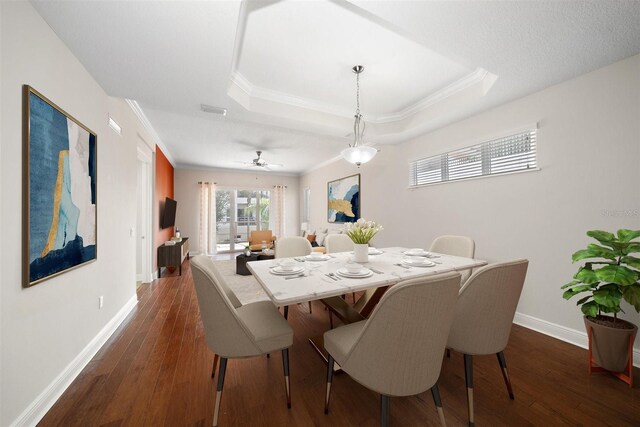 1030 Bellasol Way Unit 201, Apollo Beach, FL 33572 - dining area featuring baseboards, dark wood-style floors, crown molding, and a raised ceiling