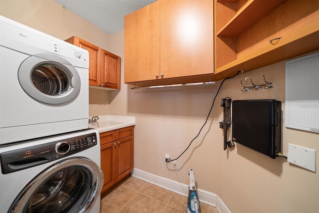 1030 Bellasol Way Unit 201, Apollo Beach, FL 33572 - clothes washing area with stacked washer and clothes dryer, cabinet space, light tile patterned floors, baseboards, and a textured ceiling