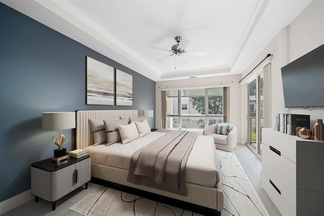 1030 Bellasol Way Unit 201, Apollo Beach, FL 33572 - bedroom with a tray ceiling, light wood finished floors, access to outside, and ceiling fan
